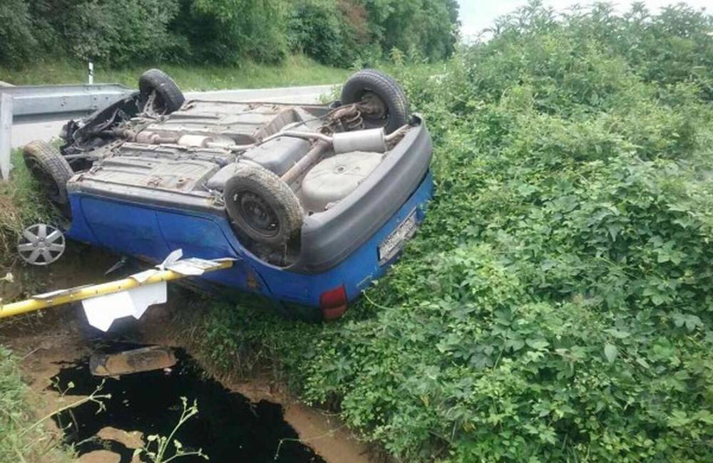 Pri Modrovke zasahovali hasiči: auto po nehode uviazlo nad potokom zachytené na orientačnej tabuli